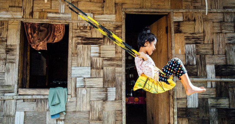 Sanjanai Kharrymba, 6 tuổi, chơi đùa trên chiếc xích đu tái chế ở trước cửa nhà.